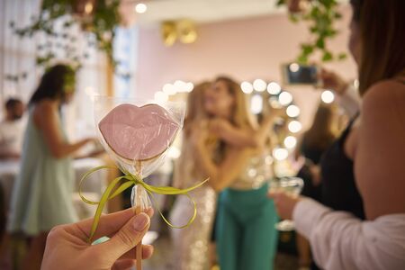 Woman holds candy in her hands in the form of lipsの写真素材
