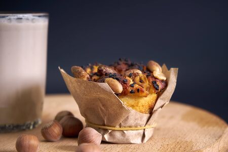On a wooden plank is food. A glass of vegetable milk and a cupcakeの写真素材