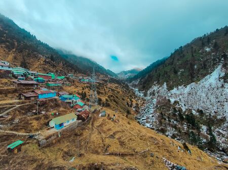 North Indian valley - Remote houses on a valley of Sikkim with a mountain of ice besideの写真素材