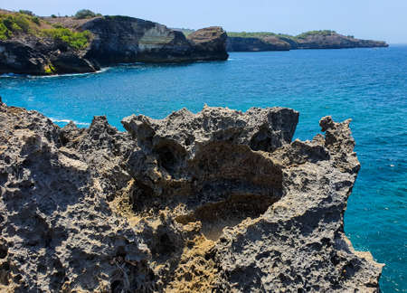 Beautiful cliff at the edge of a mountain with the Bali Sea in the background in Nus Penida Island in Bali, Indonesia. Beautiful blue sea with Mountainsの写真素材
