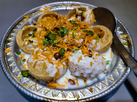 Doi Fuchka - famous and unique south asian food served on a silver plate. Fried panipuri with sweet milk and masala - South asian traditional foodの写真素材