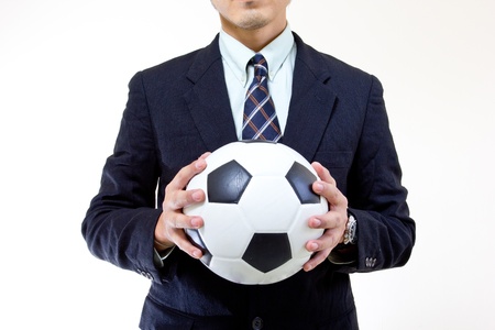 Football manager hold ball with his hands in studioの写真素材