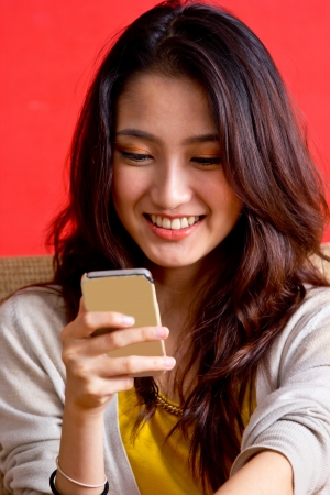 Portrait beautiful Asian Girl play smart phone in studioの写真素材