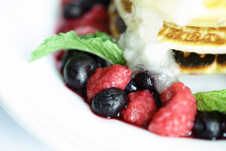Mixed berry pancakes on the white dishの写真素材