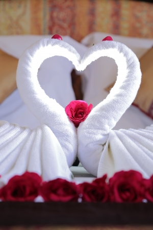Close up sweet heart white cloth on the bed of hotelの写真素材
