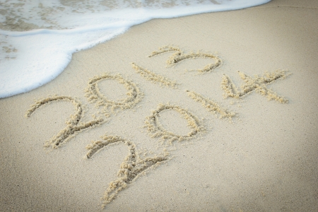 2013 and 2014 text have been written on the beach with concept New Yearの写真素材