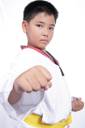 Handsome taekwondo boy trained fight activity with white backgroundの写真素材