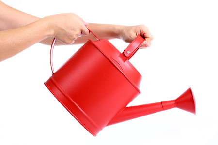 Women used hand holding Red Watering pot with white backgroundの写真素材