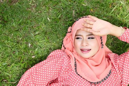 Lovely muslim girl lying on the natural grass.の写真素材