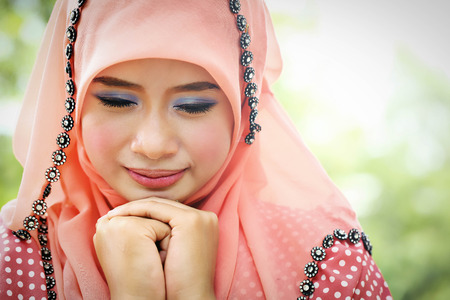 Beautiful muslim girl pink hijab wearing fashion in the nature.の写真素材
