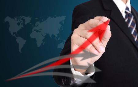 Businessman writing Red glowing graph for build his business の写真素材