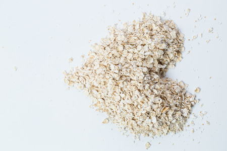 Macro Oat flakes pile heart  on the white backgroundの写真素材