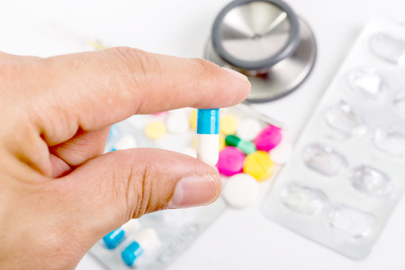 Use hand hold a pill wite white backgroundの写真素材