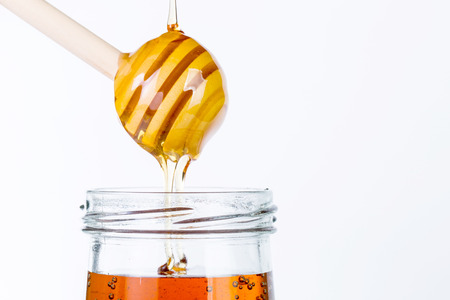 Honey diping and dipper isolated with white backgroundの写真素材