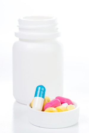 Pills and drug container isolated with white backgroundの写真素材