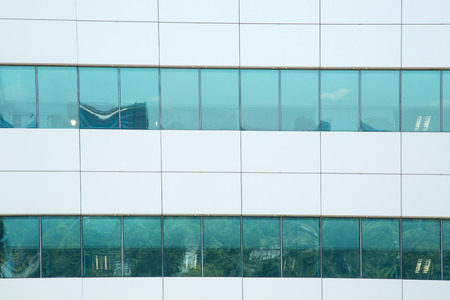 Office building and green mirrored glass with blue sky