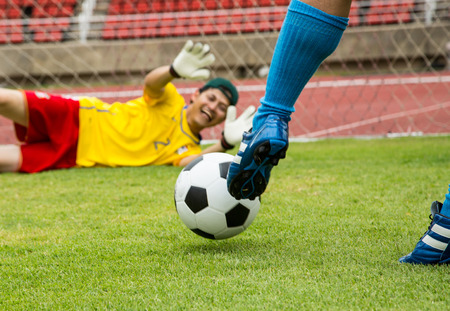Attack soccer player shooting to defense team in football stadium.の写真素材