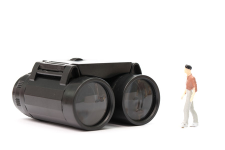 Businessman doll stand on top of binoculars in concept of show visionの写真素材