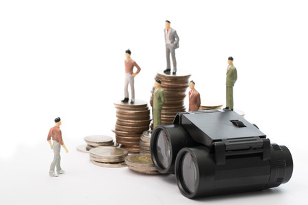 Businessman dolls stand on top of binoculars in concept of show visionの写真素材
