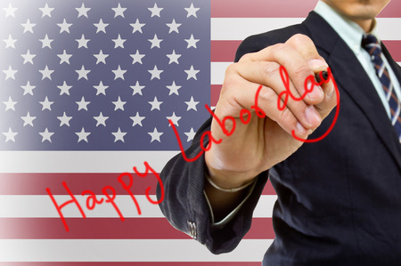 Businessman hand write Happy labor day with USA Flagの写真素材