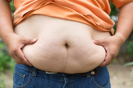 Fat man used hand for check his weight with overweight conceptの写真素材