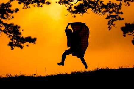 Young man run and hold Fabric for joy his freedom in the natureの写真素材