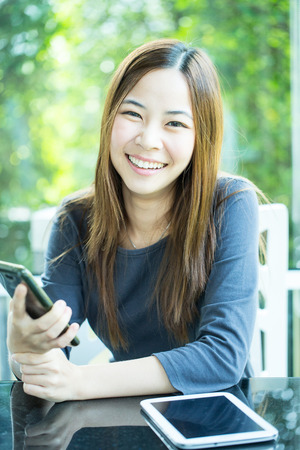 Young Asian girl use tablet for search information in coffee shopの写真素材
