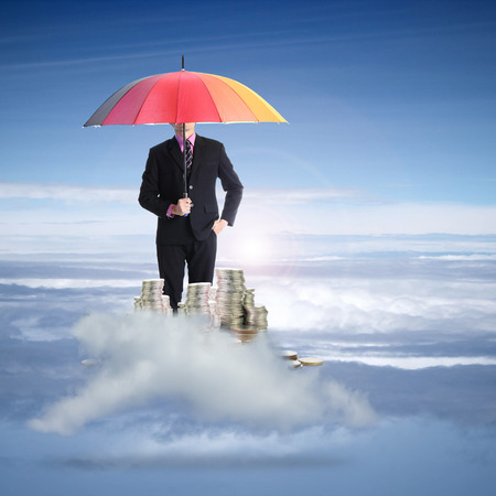 Businessman holding rainbow umbrellaの写真素材