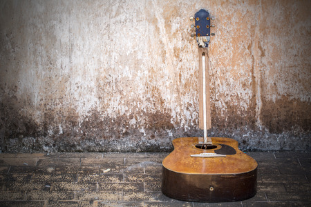 Shattered Guitar beside old wallの写真素材