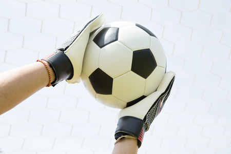 Goalkeeper used hands for catches the ball in match gameの写真素材