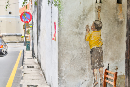GEORGE TOWN,PENANG ,MALAYSIA- CIRCA March 26, 2015: Public street art Name Street Mural entitled Reaching Up on the wall by Ernest Zacharevic in Georgetown, Penang, Malaysia.のeditorial素材