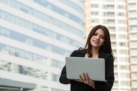 Businesswoman holding laptop for search and check information reportの写真素材