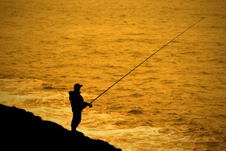 Fisherman fishing a perpon beside the sea.の写真素材