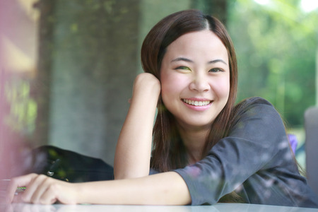 Young Asian women looking  beside mirror in cafe shopの写真素材