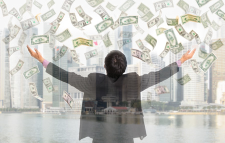 Businessman catching money with open arm with white backgroundの写真素材