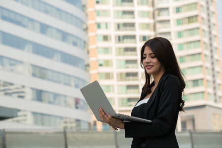Businesswoman holding laptop for search and check information reportの写真素材