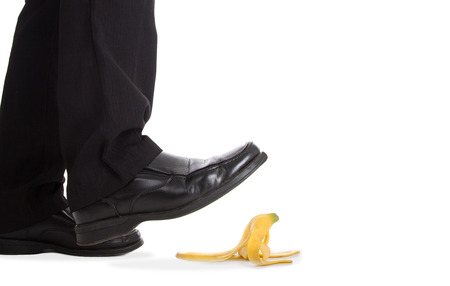Businessman walking foot press banana peel and slip fall to floor.の写真素材