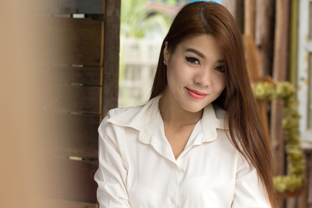 Young businesswoman sitting in coffee shop for check and search internet in the outside.の写真素材