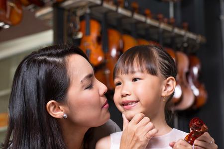 Mam and daughter portrait with violin in studio school.の写真素材