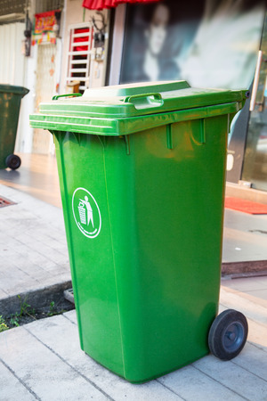 Green trashcan for trash garbage to its.の写真素材