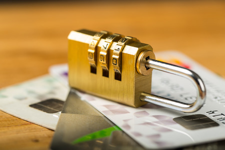 combination lock and credit cards on wood board.