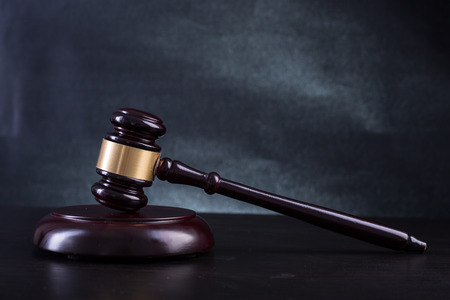 Wooden Judges gavel with black background.