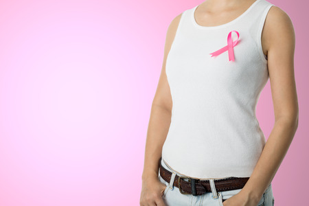Pink Breast cancer awareness ribbon sticked by woman who need to show healthcare concept.の写真素材