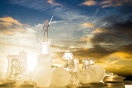 Business competition chess battle strategy game. Businessman stand over a chess after victory.の写真素材