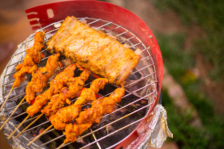 Barbecue grill chicken and pork meat cooking in the garden.
