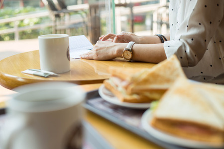 Mobile lifestyle. Asian woman use smart phone for chat and work in coffee shop.の写真素材