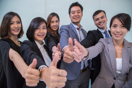Thumbs up business people for show successful team in the office.の写真素材