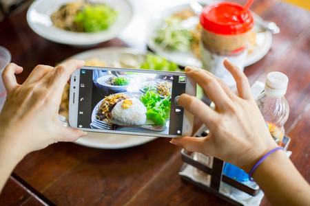 People use smart phone for taking photo food. Breakfast food in the morning.