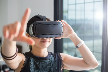 VR technology headset for reality virtual watching 3D, woman holding equipment for looking movie.の写真素材