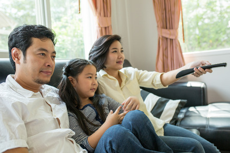 Asian family watching tv at Home.の写真素材